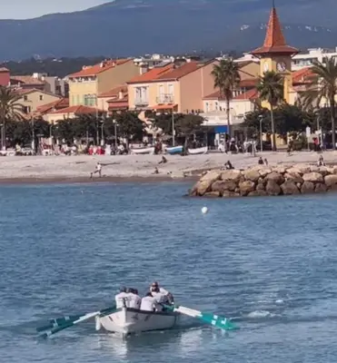 a man in a boat in the water near a beach at Cros de Cagnes Pins Sud Évasion in Cros-de-Cagnes