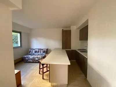 a kitchen with a table and a couch in a room at Cros de Cagnes Pins Sud Évasion in Cros-de-Cagnes