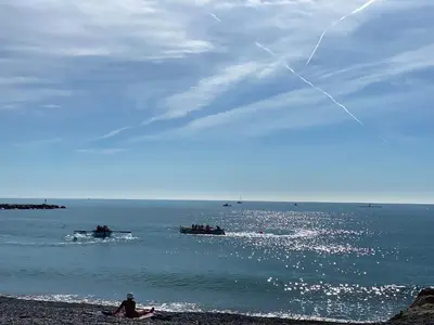 a person sitting on the beach flying a kite at Cros de Cagnes Pins Sud Évasion in Cros-de-Cagnes