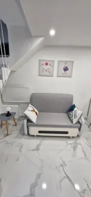 a living room with a couch on a marble floor at Magnifique appartement 2 pièces - Port de Nice in Nice