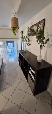 a living room with a black cabinet with vases on it at Magnifique appartement 2 pièces - Port de Nice in Nice