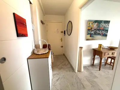 a hallway with a table and a clock on the wall at t3 cagnes sur mer in Cagnes-sur-Mer