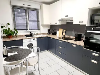 a kitchen with blue cabinets and a table and chairs at Sunny Escape in Nice