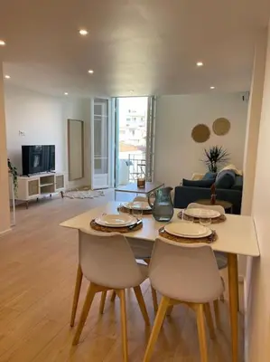 a living room with a table and two chairs at Appartement à 2 pas de la mer et Parking privé in Nice