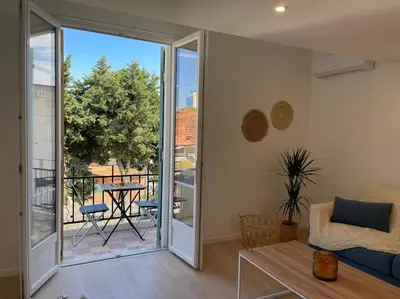 a living room with a view of a balcony at Appartement à 2 pas de la mer et Parking privé in Nice