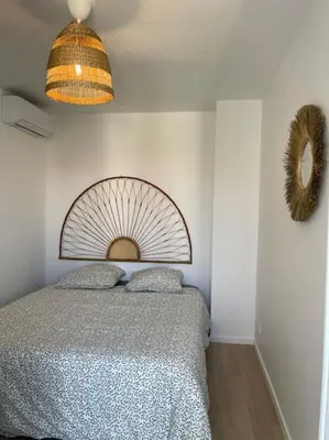 a bedroom with a bed and a mirror on the wall at Appartement à 2 pas de la mer et Parking privé in Nice