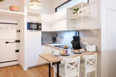 a kitchen with a wooden table and white cabinets at L59 Appartment La Loge Vieux Nice, central AC & WIFI in Nice