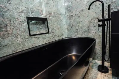 a black bath tub in a bathroom with a mirror at Appartement Belle Époque cœur de ville -AC- in Nice