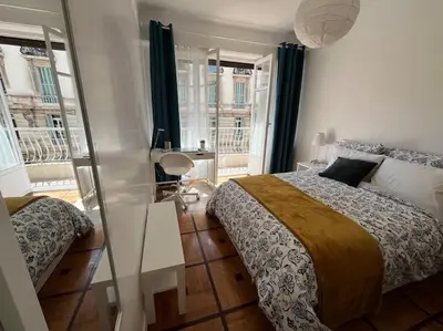 a bedroom with a bed and a table and windows at Sunny Gambetta with 3 air conditionings in Nice