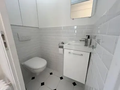 a white bathroom with a toilet and a sink at Sunny Gambetta with 3 air conditionings in Nice