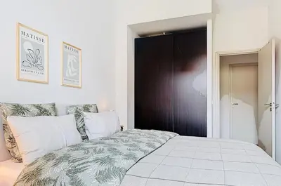 a bedroom with a bed and a black door at Charming 2-Bedroom Retreat Near City Center with Excellent Transport Links in Nice