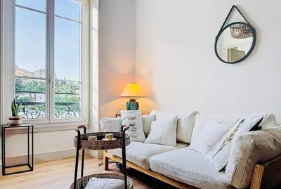 a living room with a white couch and a window at Charming 2-Bedroom Retreat Near City Center with Excellent Transport Links in Nice