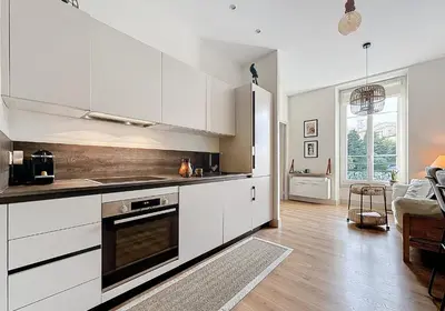 a kitchen with white cabinets and a sink at Charming 2-Bedroom Retreat Near City Center with Excellent Transport Links in Nice