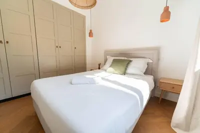 a large white bed in a room with white cabinets at Superbe appartement deux chambres, centre proche port in Nice