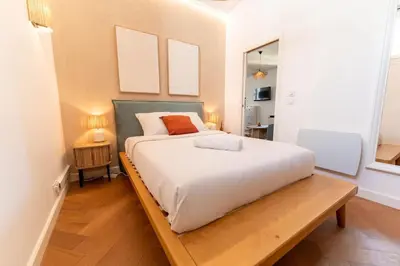 a bedroom with a large bed and a wooden table at Superbe appartement deux chambres, centre proche port in Nice