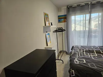 a bedroom with a bed and a dresser and a window at L'escapade vers le bien-être in Nice