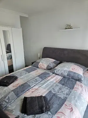 a bedroom with a bed with a blanket and pillows at L'escapade vers le bien-être in Nice