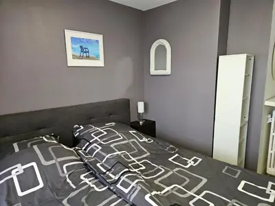 a bedroom with a bed with a gray and white bedspread at L'escapade vers le bien-être in Nice