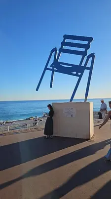 a woman standing under a chair on the beach at L'escapade vers le bien-être in Nice