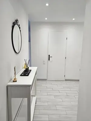 a white bathroom with a vanity and a mirror at L'escapade vers le bien-être in Nice