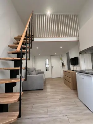 a kitchen and a living room with a spiral staircase at Studio Roma - Jean Médecin - LA RIVIERA LCD in Nice