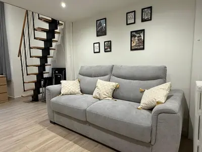 a gray couch in a living room with pictures on the wall at Studio Roma - Jean Médecin - LA RIVIERA LCD in Nice