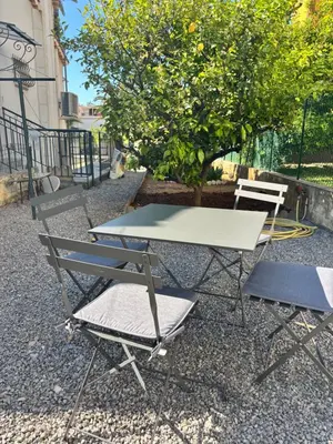 a picnic table and two chairs sitting next to a tree at Charmant T3 Rénové Proche Mer, Aéroport et Gare ! in Saint-Laurent-du-Var
