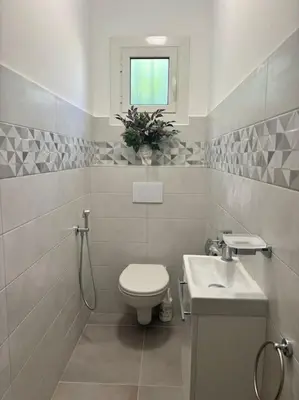a bathroom with a toilet and a sink and a window at Charmant T3 Rénové Proche Mer, Aéroport et Gare ! in Saint-Laurent-du-Var