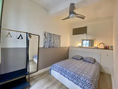 a bedroom with a bed and a ceiling fan at Joli appartement niçois en bord de mer in Nice