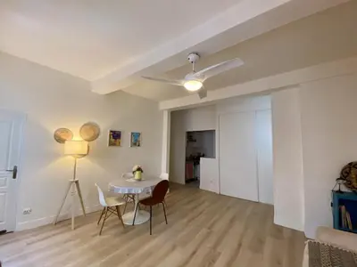 a white living room with a table and chairs at Joli appartement niçois en bord de mer in Nice