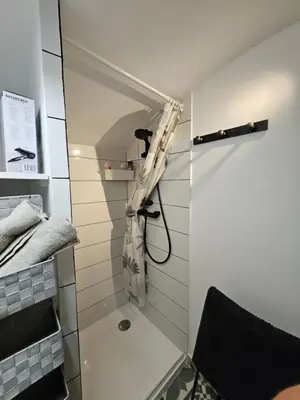 a shower with a shower curtain in a bathroom at Atypique studio en bas du Château in Cagnes-sur-Mer