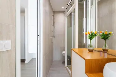 a bathroom with a toilet and a sink with flowers on a counter at Esterel AP4431 By Riviera Holiday Homes in Villefranche-sur-Mer