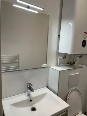 a white bathroom with a sink and a mirror at Ete Nice in Nice