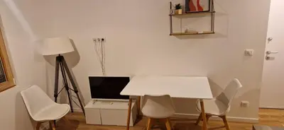 a white table and chairs in a room with a television at Ville nice in Nice