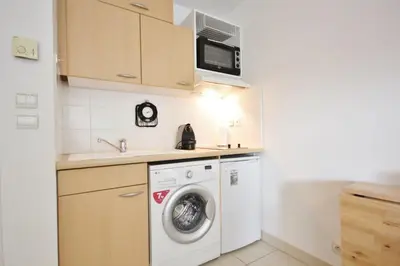a kitchen with a washing machine and a microwave at Le Palais de Med Studio Promenade des Anglais in Nice