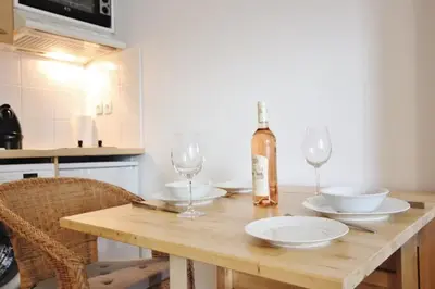 a wooden table with two glasses and a bottle of wine at Le Palais de Med Studio Promenade des Anglais in Nice