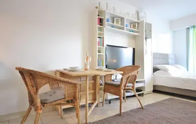 a room with a desk and two chairs and a bed at Le Palais de Med Studio Promenade des Anglais in Nice