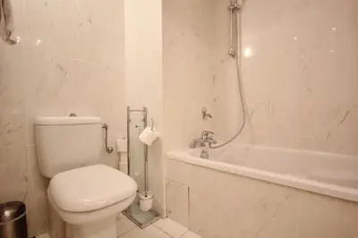 a white bathroom with a toilet and a bath tub at Le Palais de Med Studio Promenade des Anglais in Nice