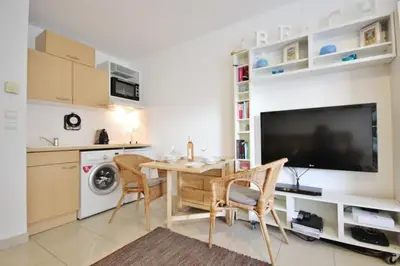 a kitchen with a table and chairs and a television at Le Palais de Med Studio Promenade des Anglais in Nice