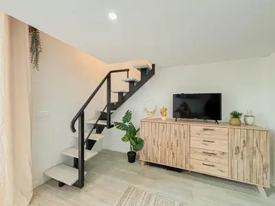 a living room with a staircase next to a tv at Potiers - parking, Wifi, 2pers in Nice