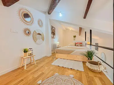 a bedroom with a large bed and a wooden floor at Potiers - parking, Wifi, 2pers in Nice