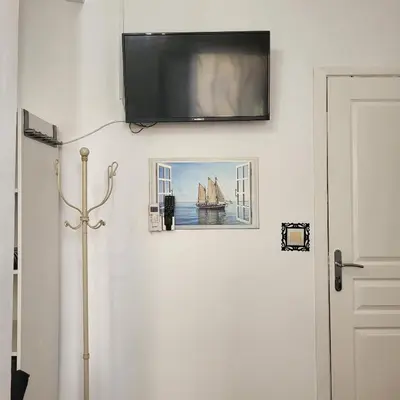 a flat screen tv on a wall above a door at Studio centre ville in Nice