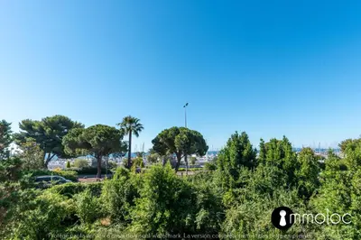 a group of trees and palm trees in a park at Air-conditioned apartment facing the port of Saint Laurent with 2 bedrooms in Saint-Laurent-du-Var