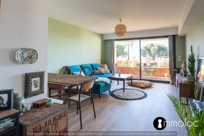a living room with a blue couch and a table at Air-conditioned apartment facing the port of Saint Laurent with 2 bedrooms in Saint-Laurent-du-Var