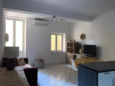 a living room with a couch and a tv at Rue St Gaetan location old town in Nice