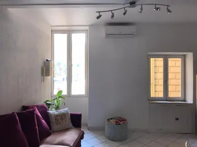 a living room with a couch and a window at Rue St Gaetan location old town in Nice