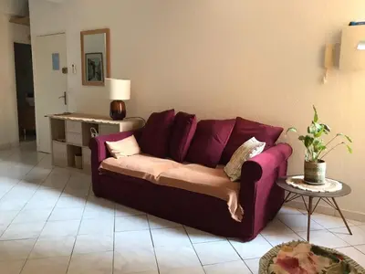 a purple couch in a living room with a table at Rue St Gaetan location old town in Nice