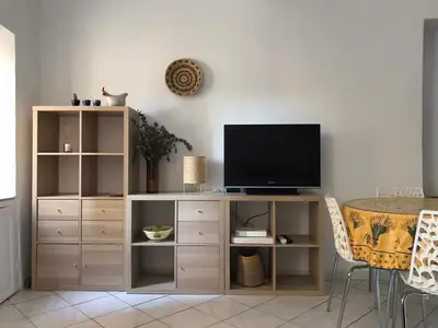 a entertainment center with a television and a table at Rue St Gaetan location old town in Nice