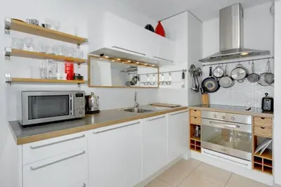 a white kitchen with a sink and a microwave at Villa Kappas - B42 Promenade des Anglais in Nice