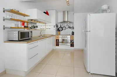 a kitchen with white cabinets and a refrigerator at Villa Kappas - B42 Promenade des Anglais in Nice